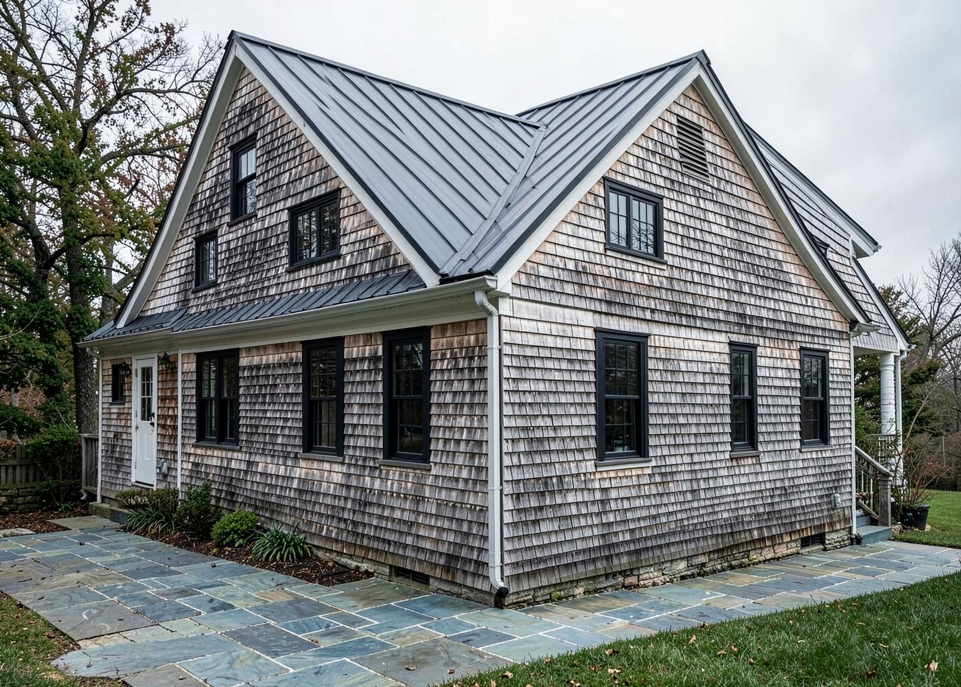 Cedar-shingled rear addition with charcoal standing seam metal roof